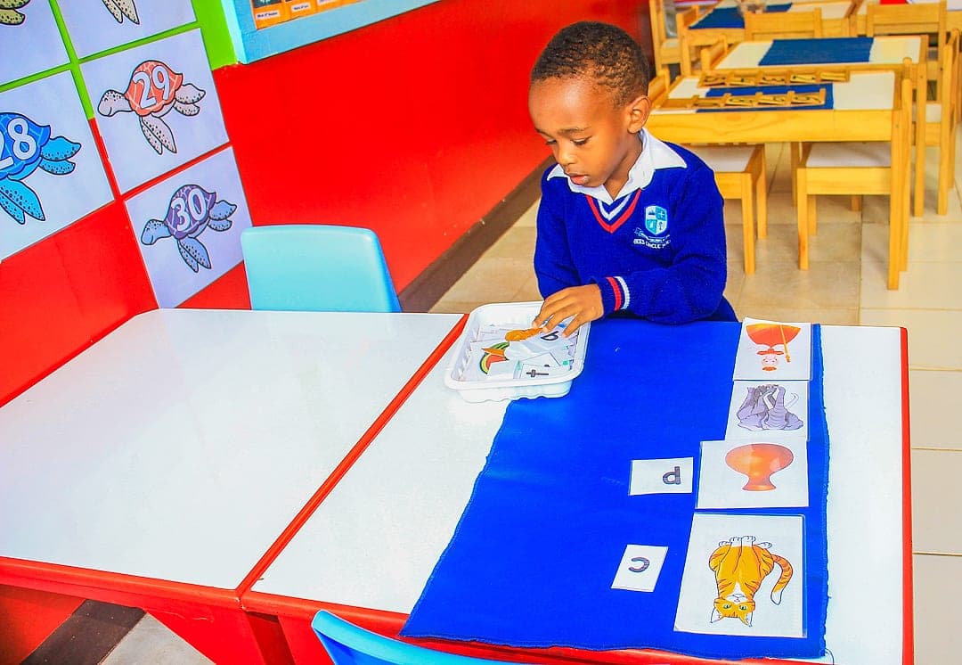 A child matching letters to pictures on a Montessori tray