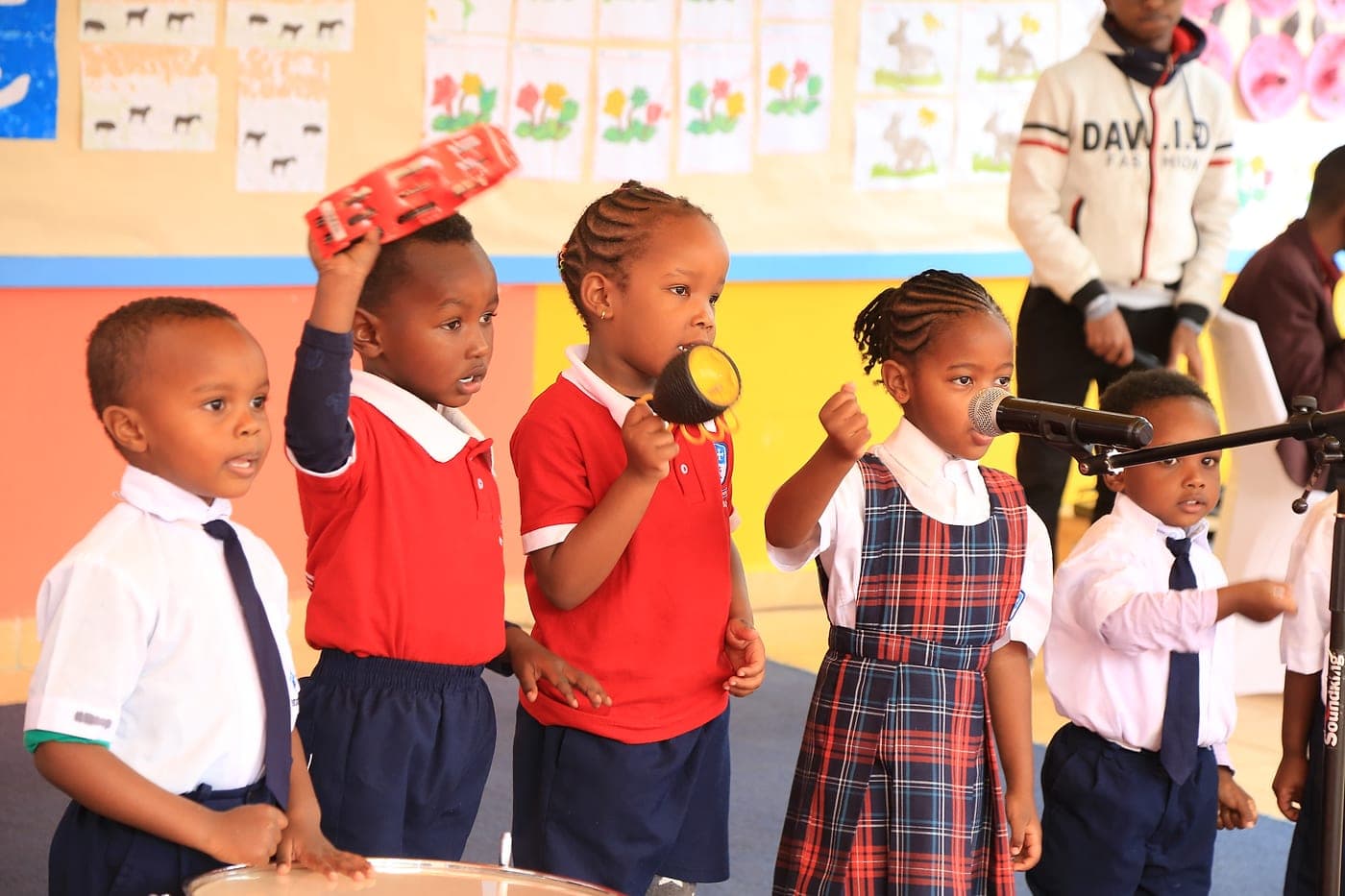 Children playing percussion instruments together at a class performance