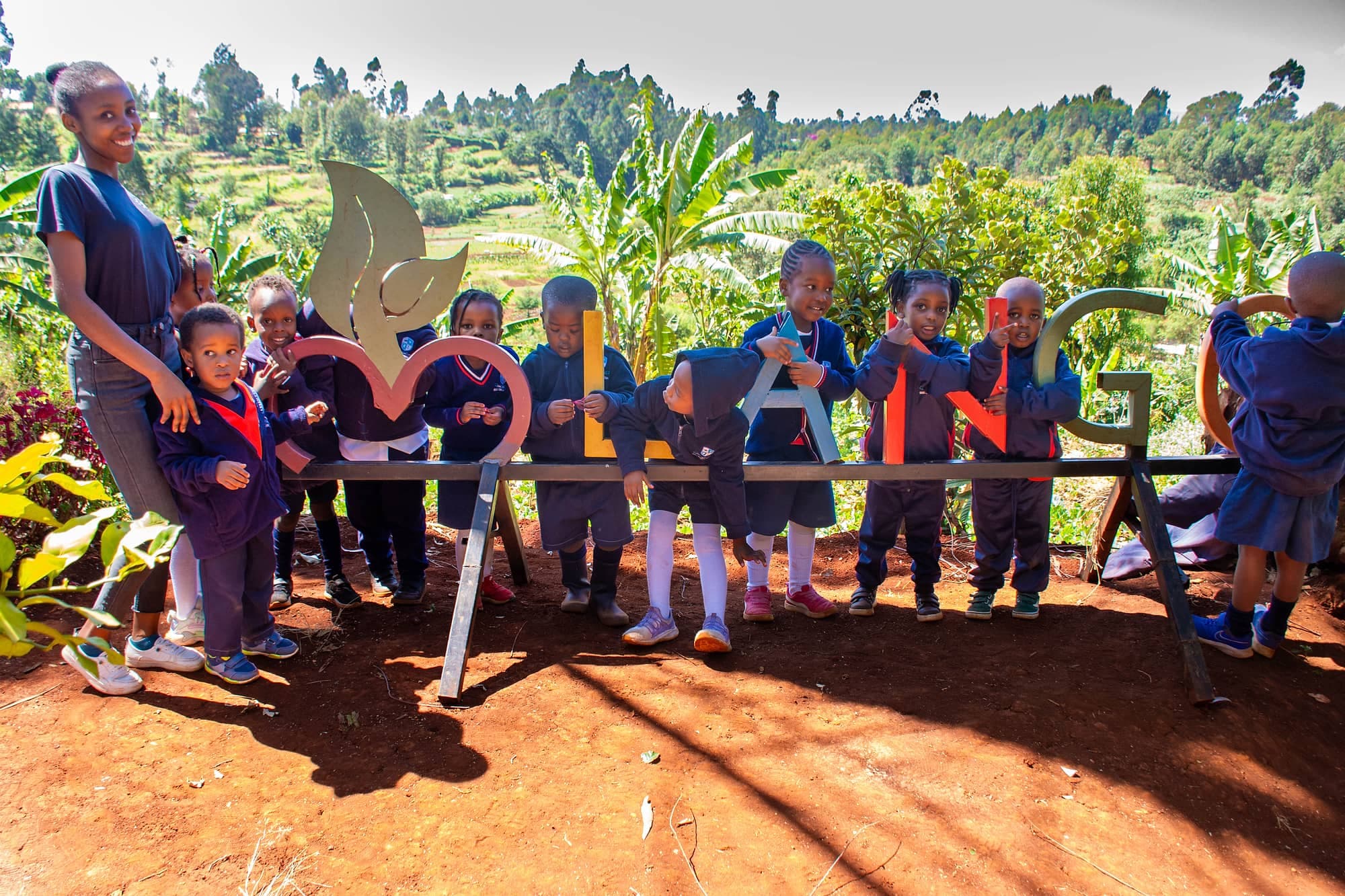 A class and their teachers at the entrance to an eco-farm